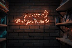 Picture of a lit up sign that reads: you are what you listen to