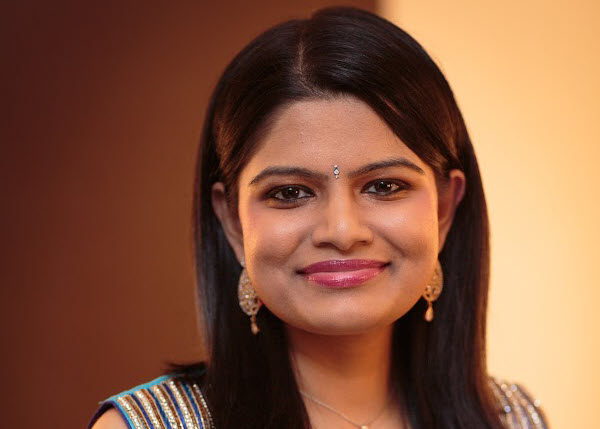 picture of Vidya Srinivasan, dark brown hair, wearing earrings and smiling