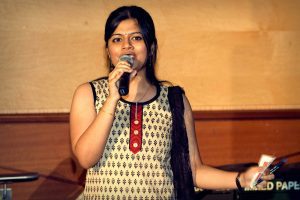 Vidya Srinivasan performing, holding a microphone