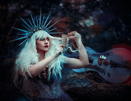 Woman with long white hair in a spiky crown with a cello in the background coming her hair